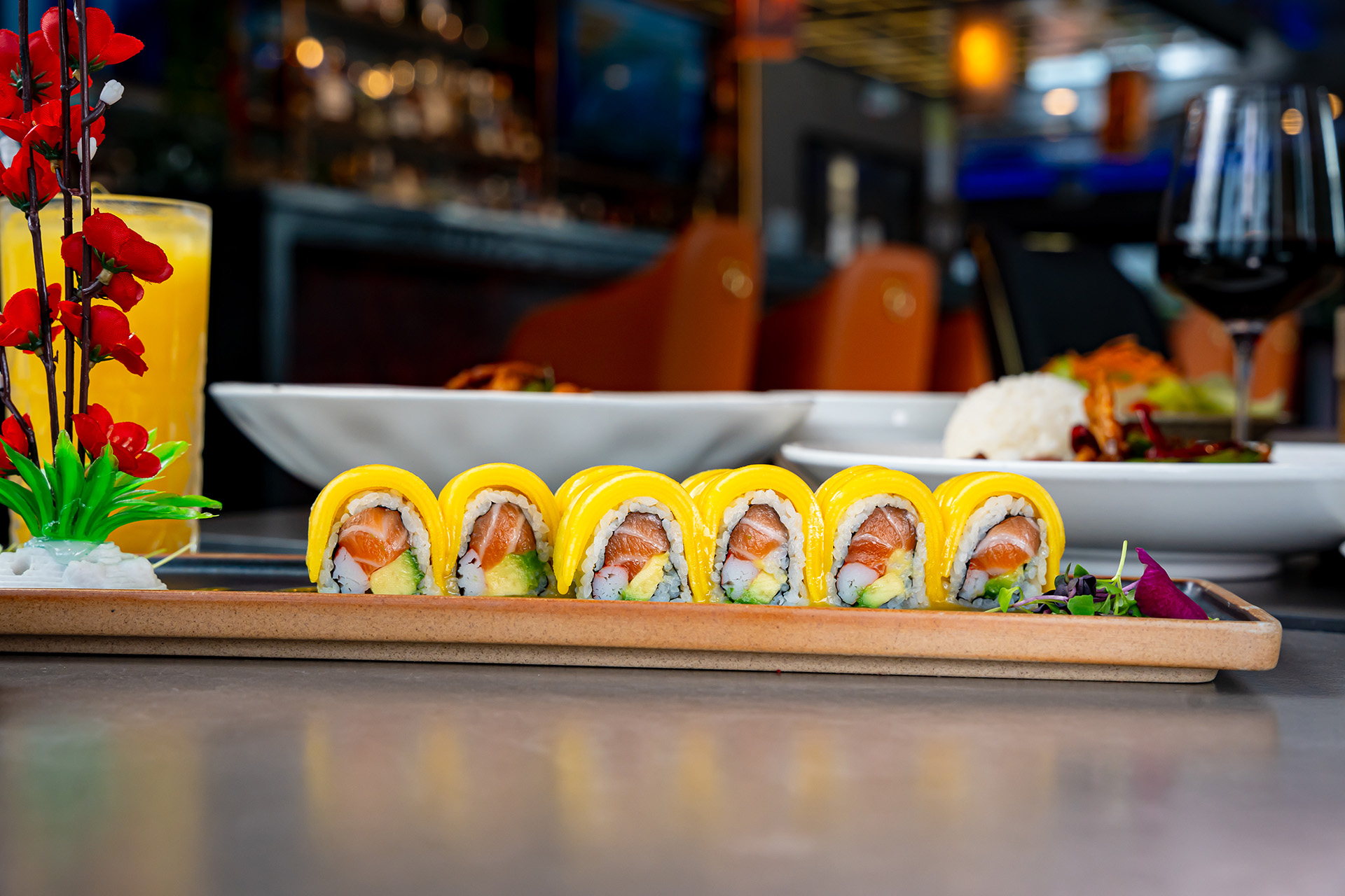 Mango-topped sushi roll on a long platter at the Cherry Amber sushi bar