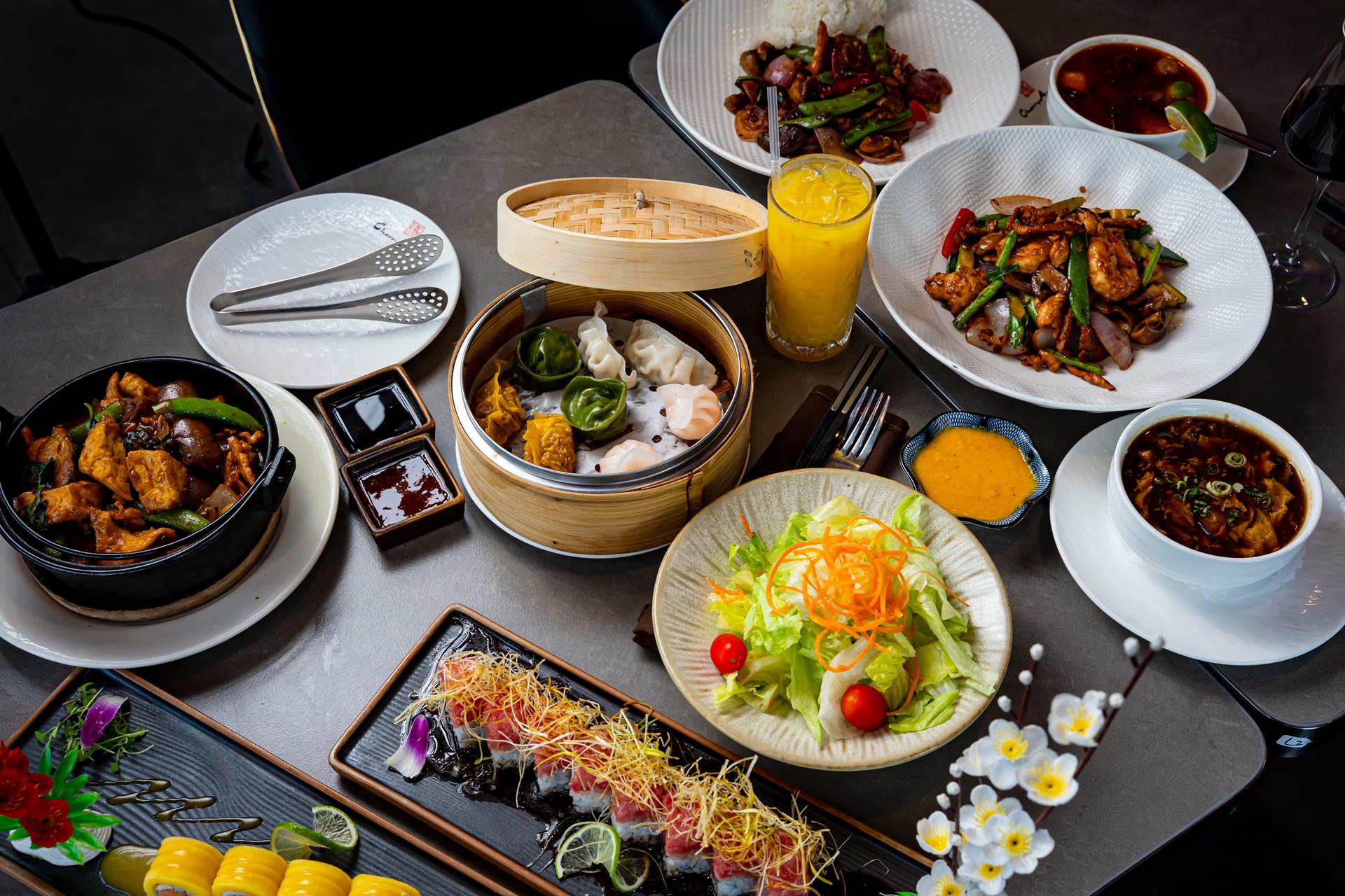 Shared table of dim sum, salad, sushi and wok dishes at Cherry Amber